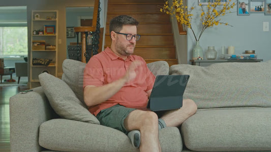 Man on Couch Looking Up Information on Weevil Infestations on His Laptop