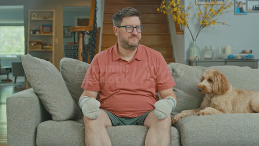 Man on Couch Feeling Content About Having Socks on His Hands
