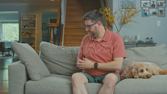 Man on Couch Pretends the Couch Has a Campfire Built Into It and Warms His Hands