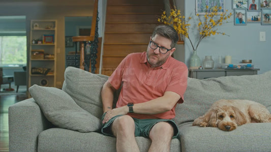 Man on Couch is Confused by Why He Has So Many Grapes in His Pockets