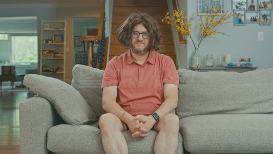 Man on Couch Wearing Attractive Wig