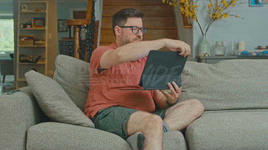 Man on Couch Looking at Laptop But Doesen't Know How Laptops Work