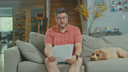 Man on Couch Reads a Handwritten Letter About the Dangers of Modern Technology
