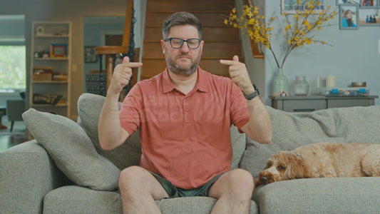 Man on Couch Tries to Touch His Two Fingers Togetehr But Can't For Some Reason