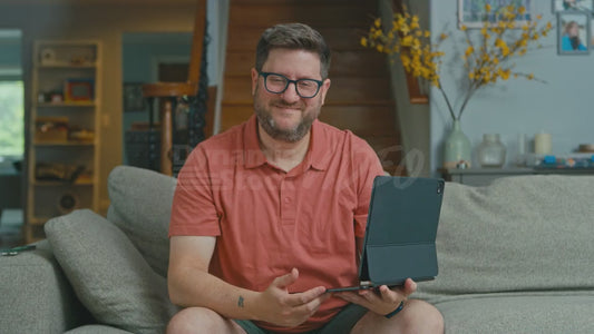 Man on Couch Wants to Show the Camera His New Laptop